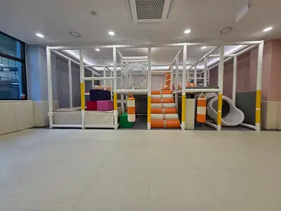 실내 놀이기구 아래까지 이어 깐 유희실 매트